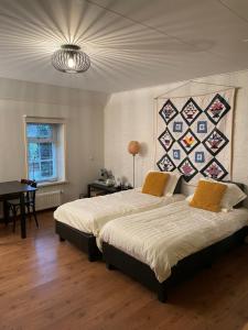 莱米尔de Stjelp Pleats的一间卧室设有两张床和一个带被子的墙壁
