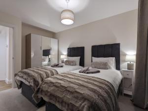 斯蒂夫尼奇Stunning 2-Bed Apartment in Stevenage, Sleeps 5 with free Private Parking的一间卧室配有两张带毛巾的床