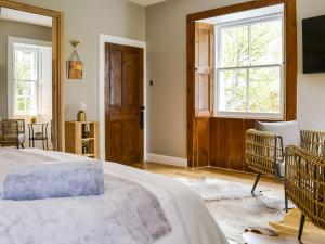 布莱尔阿瑟尔Riverside Cottage的一间卧室设有一张床、一个窗口和一台电视。