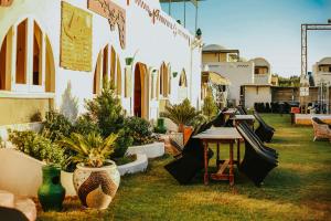 Qaryat at Ta‘mīr as SiyāḩīyahLake House by Tunisia Green Resort的一个带盆栽植物、桌子和长凳的庭院