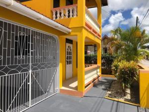 布里奇敦DonaMae 2 story Barbados House的黄色房子前面有门