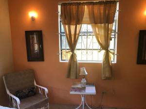 布里奇敦DonaMae 2 story Barbados House的客房设有窗户、椅子和桌子。