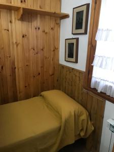 罗卡迪梅佐appartamento incantevole con camino的卧室配有一张床铺,位于带木墙的房间内