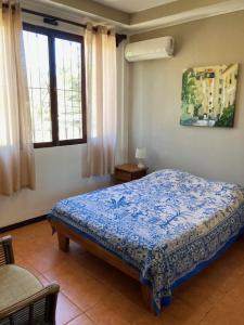 塔马林多Casa Sueno Colibri的一间设有床铺的卧室,位于带窗户的房间内