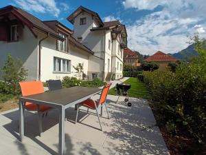 因特拉肯Henry's Apartments Interlaken的房屋前设有带桌椅的天井。