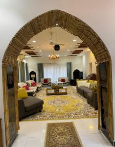 尼兹瓦Aryaf hostel的带沙发和桌子的客厅的拱门