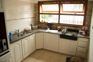 马德普拉塔Santa Cruz 5761的厨房配有白色橱柜、水槽和窗户。