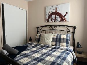 Petit-SaguenayLa Cabane chez Jimmy的一间卧室配有一张带蓝白格子毯子的床
