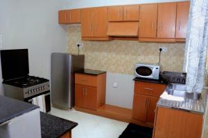 KisiiLovely 3 bedroom apartment, kisii的一间带木制橱柜和微波炉的小厨房