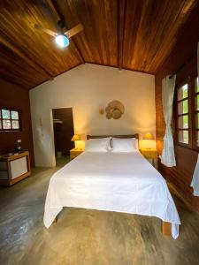 韦尔卡鲍Chalés Vila Do Vale的卧室配有一张白色大床和木制天花板