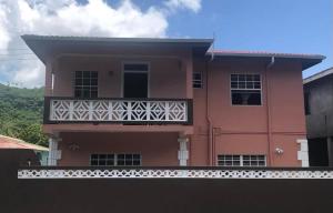 苏弗里耶尔Coco Rose Apartments的粉红色的房子前面设有一个阳台