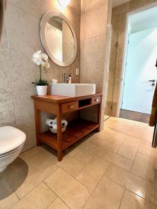 旺阿雷Mary's Tranquil B&B的一间带水槽、卫生间和镜子的浴室