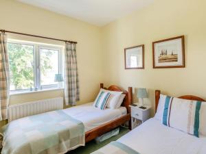 EdlingtonEdlington Hall Cottage的一间卧室设有两张床和窗户。