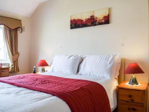 萨顿科尔菲尔德Serenity Comfort的一间卧室配有一张床铺,床上铺有红色毯子