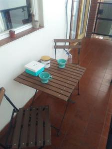马德普拉塔Depto cerca del mar的一张木桌,配有两个碗和一张长凳