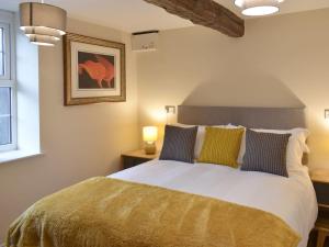 阿普比The Mews的一间卧室配有一张大床,提供黄色和蓝色的枕头