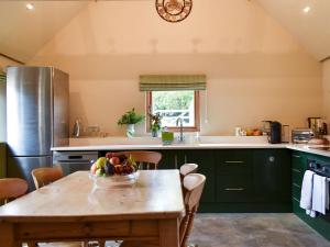 福丁布里奇Cosy Cottage - Uk34263的厨房配有一张桌子,上面放着一碗水果