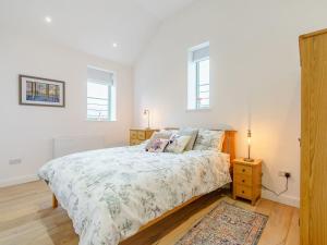 Trimdon GrangeAbigails Cottage的一间卧室配有床、床头柜和2扇窗户