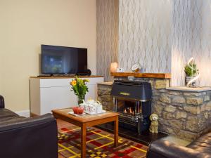 CeresMorrice House的客厅设有石制壁炉和电视。