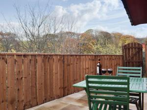 斯泰兹Pheasant Lodge的庭院设有围栏,配有桌子和两把椅子