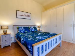 罗宾胡兹贝High Nook的一间卧室配有一张带蓝色床罩的床