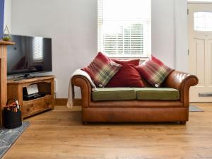 切斯特菲尔德Dark Lane的客厅里配有带枕头的棕色皮沙发