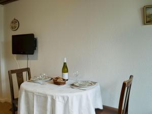 特伦Tigh Beag的一张带一瓶葡萄酒和眼镜的白色桌子