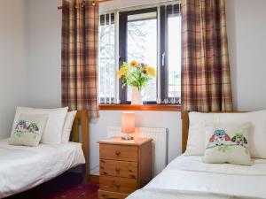 德拉姆纳德罗希特Four Winds的一间卧室设有两张床和一扇花瓶的窗户。