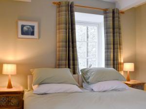 艾斯加斯Starfall的一间卧室配有带两个枕头的床和窗户