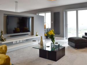 普利斯坦丁Hillside Retreat的客厅配有电视、沙发和桌子