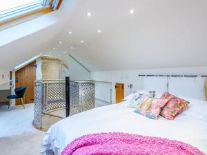 InglewhiteWoodpecker Cottage的卧室配有白色床和粉色毯子
