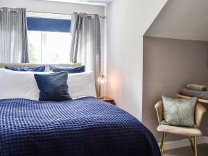 邓弗里斯River View的卧室配有蓝色和白色的床和窗户。
