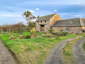 CheswickDowie House Steading的土路上的一座老石屋