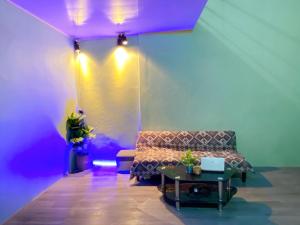 Kiến AnCúc cu Homestay 3的一间配备有沙发、桌子和紫色灯的客房