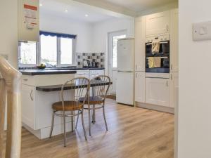卡里翁湾Caddie - Uk11038的一间厨房,配有白色家电和两把椅子