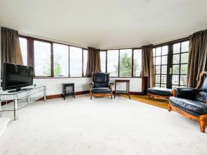 EmboFourpenny Studio - Uk34745的客厅配有电视、椅子和窗户。