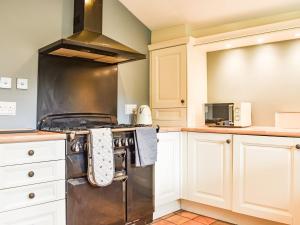 罗宾胡兹贝Chapel Cottage的厨房配有白色橱柜和炉灶。