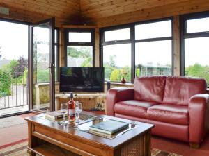 马里卡尔特Sauchenshaw Cottage的客厅配有红色沙发和茶几