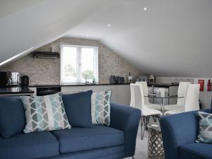 Saint LawrenceRainbows End的一间带蓝色沙发的客厅和一间厨房
