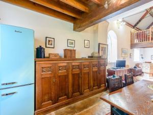 East BarkwithSt Andrews Church的厨房配有木制橱柜、桌子和冰箱。