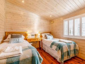WillingtonWalnut Lodge-uk37595的木墙客房的两张床
