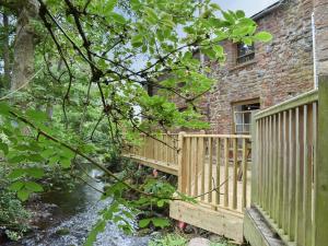 Great SalkeldThe Old Tearoom-uk32945的砖砌建筑前的木甲板