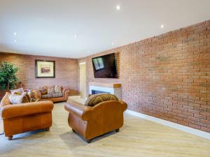 Bowness-on-SolwayThe Barnacle Goose - Uk35261的客厅设有两张沙发和砖墙