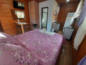 圣弗朗西斯科-迪保拉Cabanas dos Pinheiros的一间卧室配有一张带粉红色棉被的床