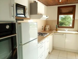 勒迪亚芒La belle Mullane的厨房配有白色橱柜、冰箱和窗户。