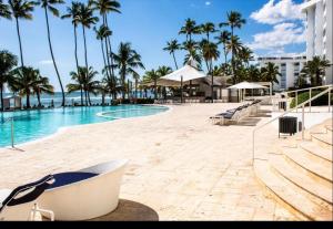 璜多里奥Marbella Juan dolio beach front luxury apartment的棕榈树游泳池及度假村
