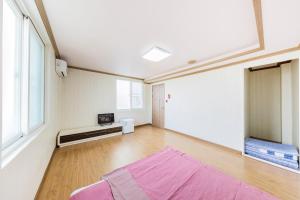 庆州Remember Youth Hostel的铺有木地板的大客房,铺有紫色地毯