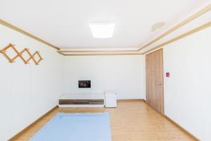 庆州Remember Youth Hostel的一间空房间,设有白色的墙壁和冰箱