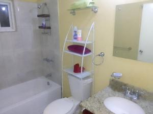 卢西Simpson's residence的浴室配有卫生间、盥洗盆和浴缸。