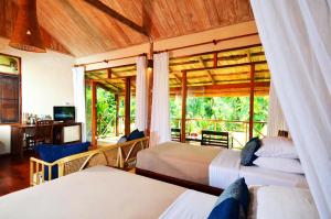 琅勃拉邦梦中精品度假村的酒店客房设有两张床和一个阳台。